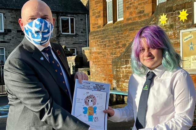 Neale Hanvey MP is pictured with competition winner Sadie Williams with her winning poster design.