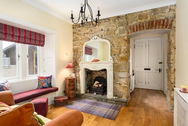 The family room with a traditional fireplace and a stone wall feature