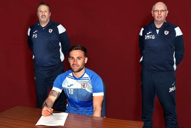Lewis Vaughan signs his contract extension with Rovers assistant boss Paul Smith and manager John McGlynn