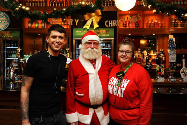 Wetherspoons staff Calum Todd and Dana Paterson with local regular Jock Allan as Santa raising money for charity. Pic: Fife Photo Agency.