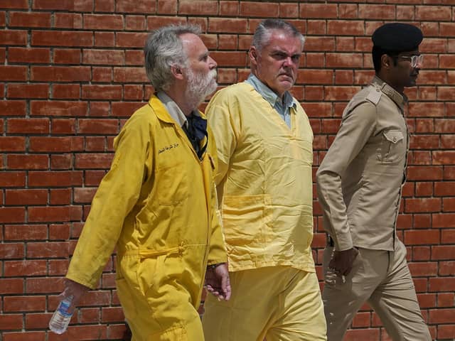 Jim Fitton of Britain, left, and Volker Waldman  escorted by Iraqi security forces, outside a courtroom, in Baghdad