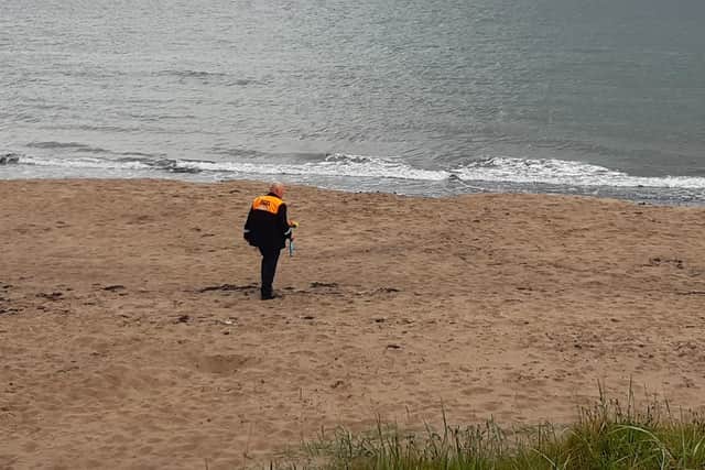 A solitary bunch of flowers is taken to be placed at the shore of the Forth to mark the 50th anniversary of the Seafield Colliery disaster