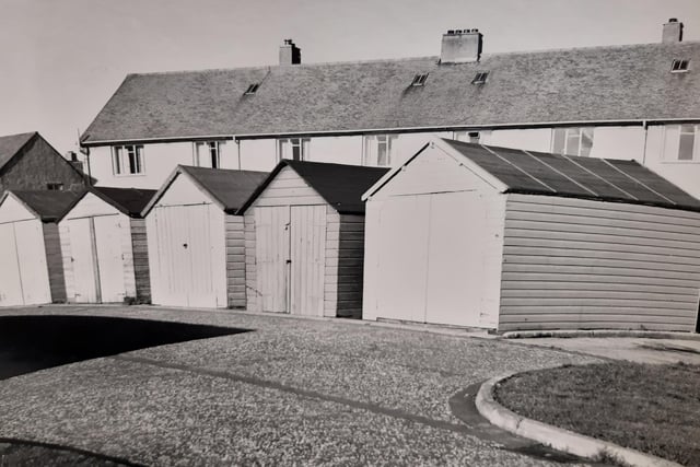 A row of lock-up garages behind houses in Glenrothes