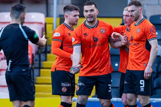 Dundee United's Tony Watt hands over a glass bottle thrown onto the pitch by a Raith Rovers supporter at Tannadice Park on Saturday (Photo by Ewan Bootman/SNS Group)