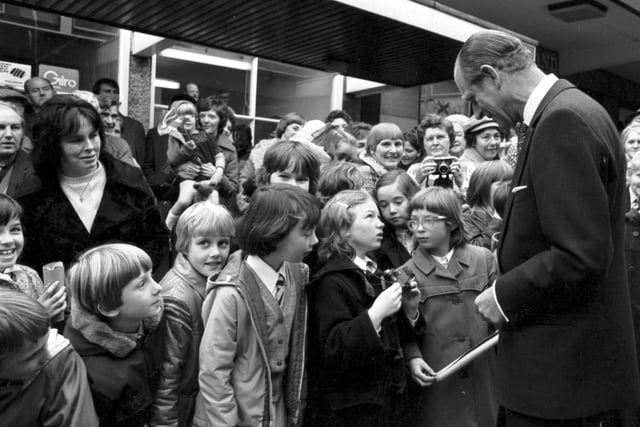 Prince Philip, the Duke of Edinburgh stops to chat with a little girl whose camera isn't working when he visits the Kingdom shopping centre in Glenrothesin 1976. The Prince asks what's wrong with it!