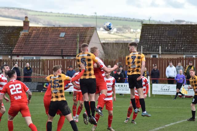 Aaron Steele (5) jumps high in the air to reach the ball for a header against Bonnyrigg Rose