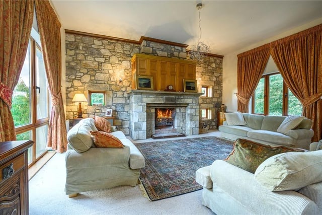 The drawing room has a vast open fireplace and incredible views of the surrounding fields.