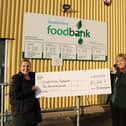 Fife Housing Group’s Alex Tweedie (left) presents Sandra Beveridge, Project Manager of the Dunfermline foodbank, with a Christmas donation.