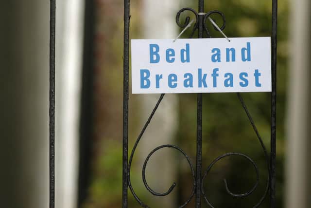 A sign promoting bed and breakfast hanging on a wrought iron gate (Pic: TSPL)