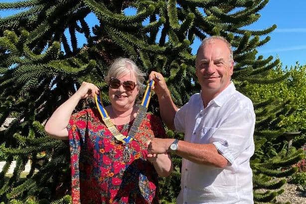Past president Dave Kelley hands over the Rotary chain of office to Susan Leslie.