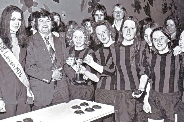 Ladies' five-a-side indoor football competition at The Centre, Leven,in  1975. 
Presenting the prizes are Miss Leven Laura Mellis and Michael Morris of Johnny’s Bingo.