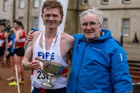 Logan Rees being presented with his prize for winning Saturday's national cross-country championships at Falkirk by Scottish Athletics president Ron Morrison (Photo: Bobby Gavin)