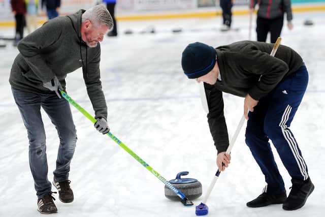 Sweeping ahead of the stone to reduce friction on the ice (picture by Fife Photo Agency)