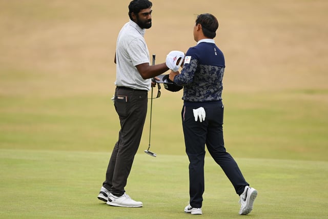 Sahith Theegala of the United States and Si Woo Kim of South Korea shake hands on the 18th green during Day Three of The 150th Open at St Andrews Old Course on July 16, 2022 in St Andrews, Scotland. (Photo by Ross Kinnaird/Getty Images)