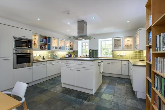 Triple aspect bespoke fitted kitchen with large island and integrated appliances.