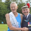 Glenrothes' John Thomson received his prize for winning the Open 1600 metres handicap from Games Chieftain John Gilfillan (Pic: Ian Grieve/RSHGA)