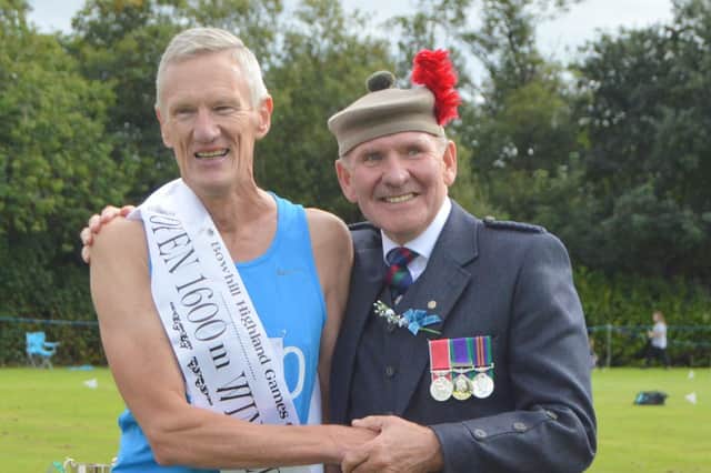 Glenrothes' John Thomson received his prize for winning the Open 1600 metres handicap from Games Chieftain John Gilfillan (Pic: Ian Grieve/RSHGA)