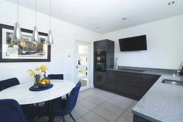 The stunning kitchen has ample base mounted cupboards, contrasting granite worktops, fitted stainless steel sink, integrated appliances, and enough room for a dining table.