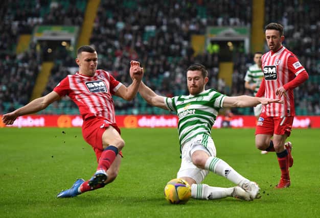 Ross Matthews battles for possession of the ball with Celtic's Anthony Ralston. (Photo by Mark Runnacles/Getty Images)