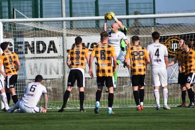 East Fife goalkeeper Jude Smith makes a confident catch in the air, fending of the challenge of Alloa's Connor Sammon.