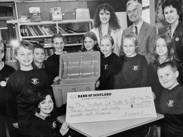 A 1996 donation from pupils at Newcastle Primary School, Glenrothes, to the Scottish Cot Death Trust. Pictured are Fiona Waddel, fundraiser, Ishbell Kerr, headteacher and Dr Angus Gibson from the trust. The picture was taken by a photographer from the Glenrothes Gazette.
