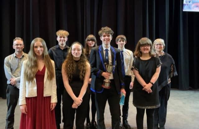 The competitors in the final of the Young Musician class along with the Adjudicators.  Back row, from left: Steven Cowling, Adjudicator; Jack Kitchen – vocal, Kirkcaldy; Tara McGhie – saxophone, Wormit; Daniel Armstrong – cello, Blebo Craigs; Karol Fitzpatrick, Adjudicator.  Front row, from left: Bethany Anna Woodburn – piano, Dunfermline; Libby Hamilton – tuba, Kirkcaldy; Alex Harrower – electric guitar, Kirkcaldy; Emma Roberts – percussion, Kinghorn.