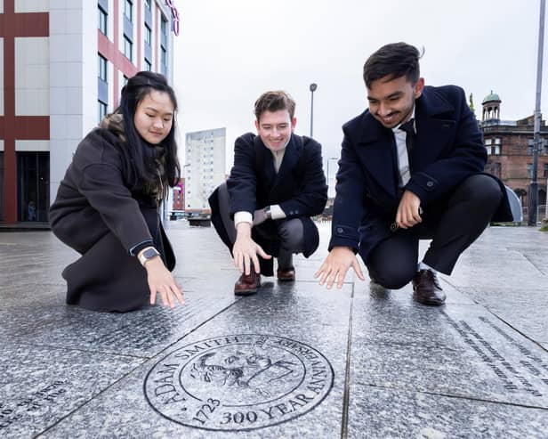 Ashley Chai, Alessandro Peacock and Prajjwal Prajjwal – who took the lead in planning student engagement with Asdam Smith’s tercentenary – admire the memorial. (Pic: University of Glasgow)