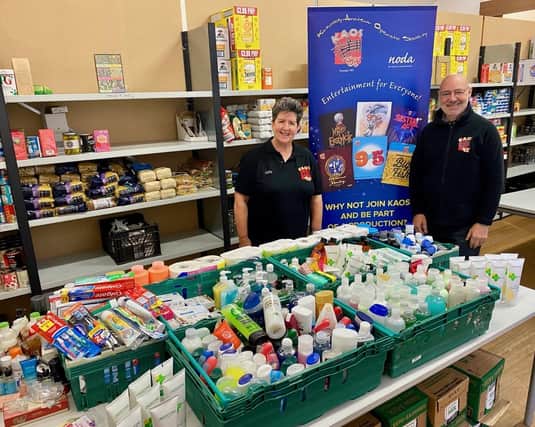 Cathy Endeacott, president, and Andrew Lowrie, marketing and publicity officer, hand over the toiletries donation from KAOS members to Kirkcaldy Foodbank.