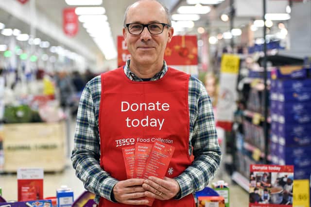 A Tesco volunteer holding a shopping list guide for donations at the launch of the Tesco Food Collection.