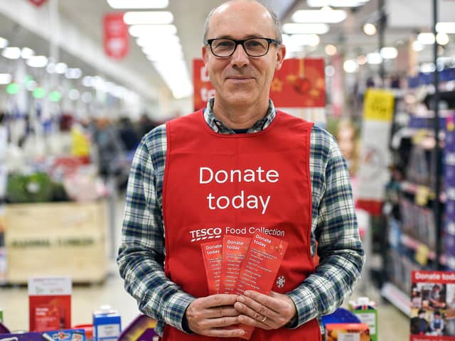 A Tesco volunteer holding a shopping list guide for donations at the launch of the Tesco Food Collection.