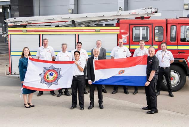 Representatives from the Scottish Fire and Rescue Service hand over Centurion to the International Fire and Rescue Association (IFRA)