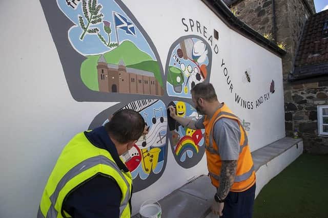 Some of the Community Payback team painting a mural in the garden of a children’s home in Freuchie.
