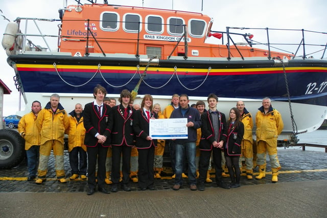 In 2011, Rachel Nee, Chairperson from Waid Academy Charities Committee, presented a cheque for £1100 to Anstruther Lifeboat Coxswain, Michael Bruce as members of the charities committee, crew and shore team look on.