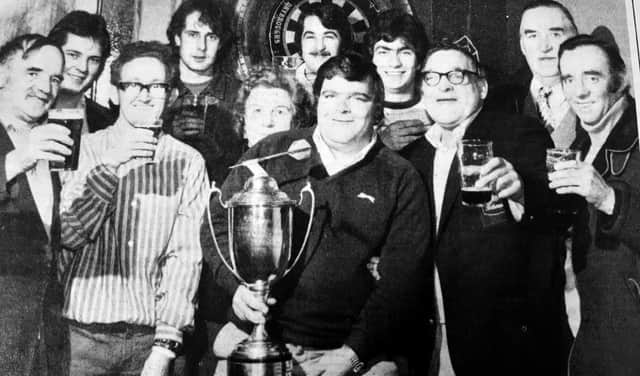 Jocky Wilson with his Embassy trophy at the Lister Bar in Kirkcaldy. His William is on his left.