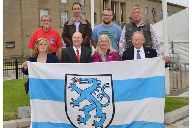 Robert Main hoists the Ingolstadt flag at the Town House in 2018. From left:  James Cooper, Ally Moghimian ,James Wallace, Les Soper, In front are Cllr Carol Lindsay,  Cllr Neil Crooks and Alice Soper.