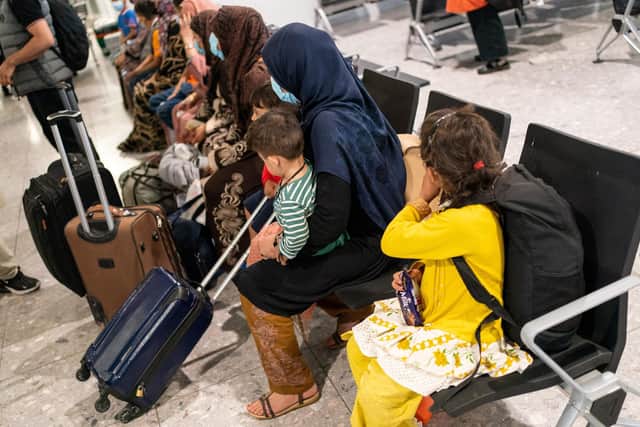 Afgan refugees wait to be processed after arriving on an evacuation flight from Afghanistan, at Heathrow Airport (Photo by DOMINIC LIPINSKI/POOL/AFP via Getty Images)