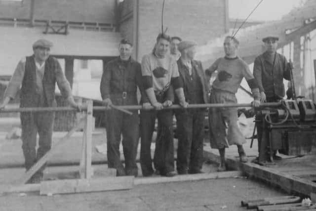 Inside the rink are some of the workers and first ice hockey players including Len McCartney (fourth from left), and Norman McQuade, who scored the very first goal, (second from right)