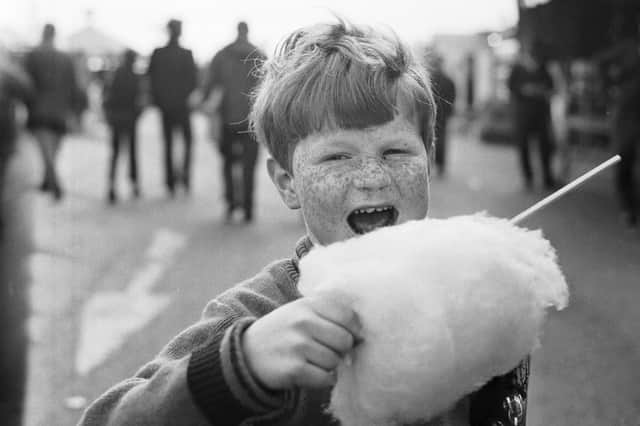Boy with freckles eating a candy floss at the Links Market in Kirkcaldy in April 1973.