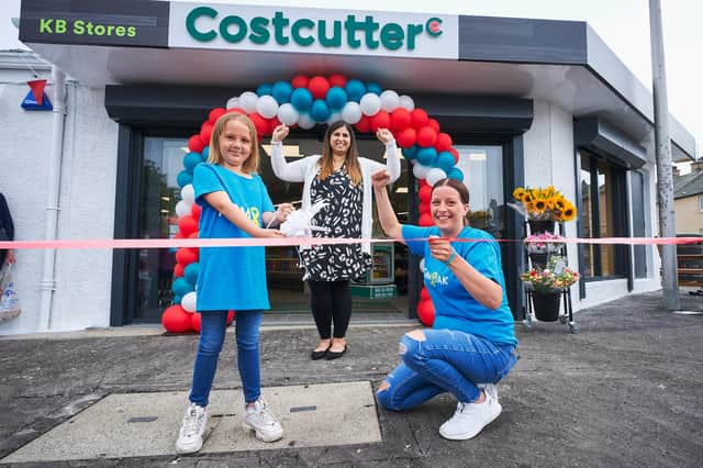 Madison Martin cuts the ribbon with her mum Samantha Kirk and store owner, Anila Anwar. Pic: Fraser Band.