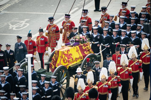 The State Gun Carriage carries the coffin of Queen Elizabeth II, draped in the Royal Standard with the Imperial State Crown and the Sovereign's orb and sceptre, as it leaves Westminster Abbey after the State Funeral of the Queen. Picture date: Monday September 19, 2022.