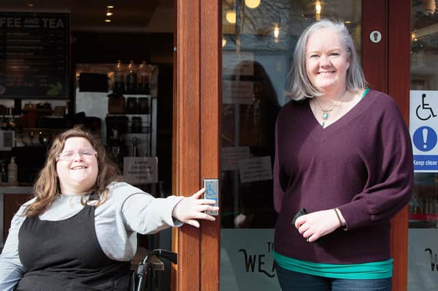 Erin Watson (left) and Zest owner Lisa Cathro try the new disabled push pad on the front door.