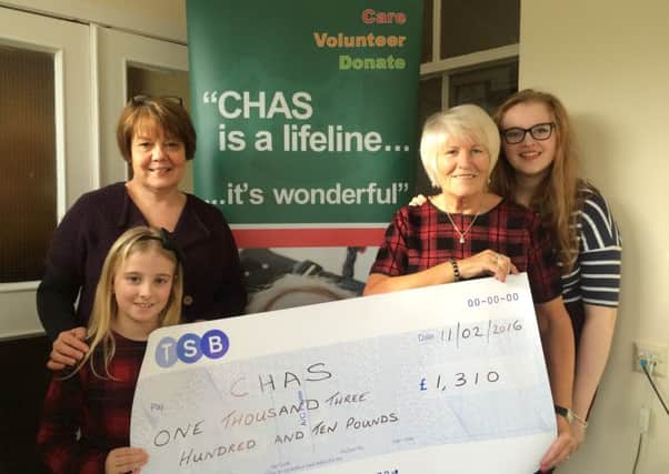Alison Rennie receives the cheque from Marie and her granddaughters Abbi and Clare