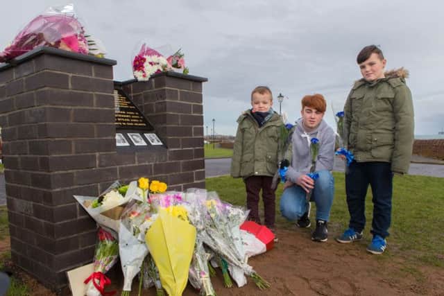 Jason Buchan's children lay flowers for their Dad; Jason (5), Denny (16) and Dylan (11)