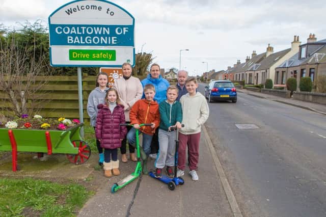 Debbie Stewart, Lynne Nicoll and Cllr Ian Sloan are pictured with local children at the entrance to the village.  Pic: Steven Brown Photography.