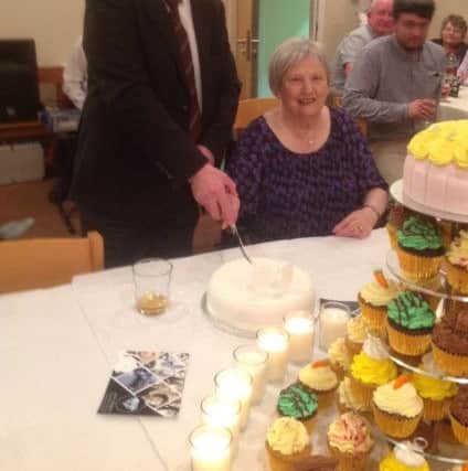 John and Theresa Gowan using the knife present by the Fife Free Press 60 years ago to cut their celebration cake