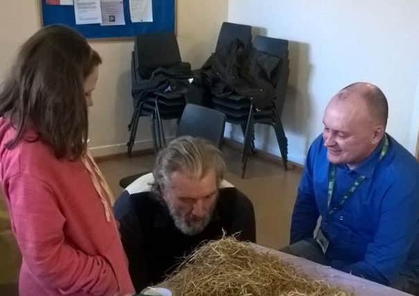 Clive Russell blowing down the little pigs house made of straw, as part of the family story
