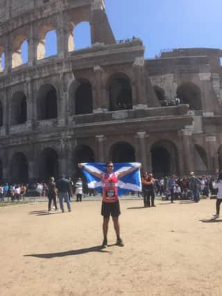 Greg Milne at the Colosseum in Rome with his medal for completing the marathon