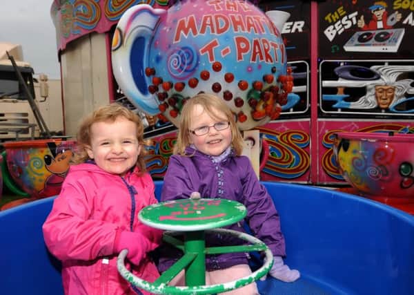 Megan (3) and Emma (4) Adams from Kirkcaldy enjoy the Mad-Hatters Tea Party, spinning cup ride at Links Market 2016. Credit - FPA.