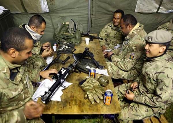 Fijian soldiers, pictured cleaning their weapons during the recent regimental range package, are a big part of the Royal Scots Dragoon Guards.