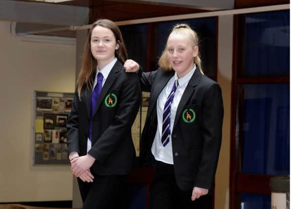Rachael Brown and Abby Falconer model the new uniforms, which will include a free purple school tie for every pupil.